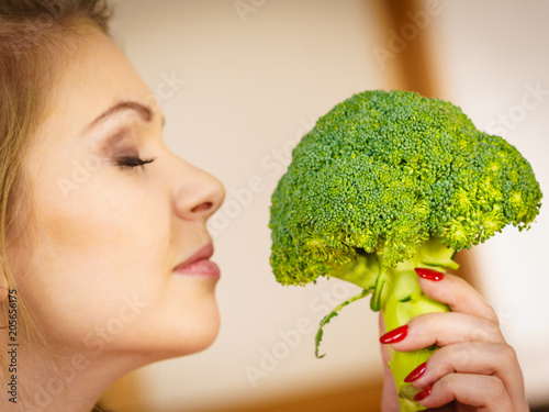 woman holding broccoli vegetable