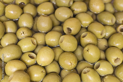 Billede på lærred Green pitted olives in marinade.