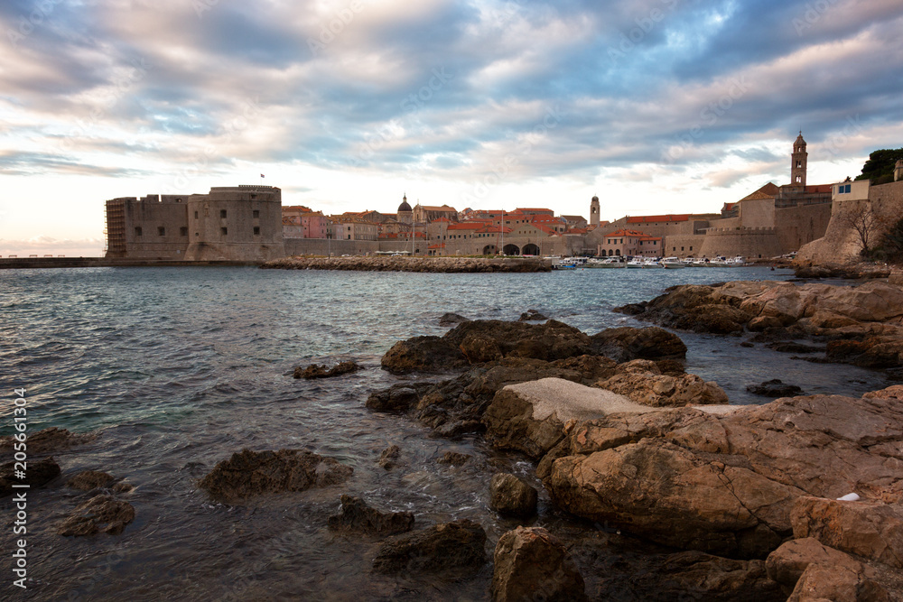 Sunset in Dubrovnik, a landscape overlooking the old town and large stones in the foreground, Croatia