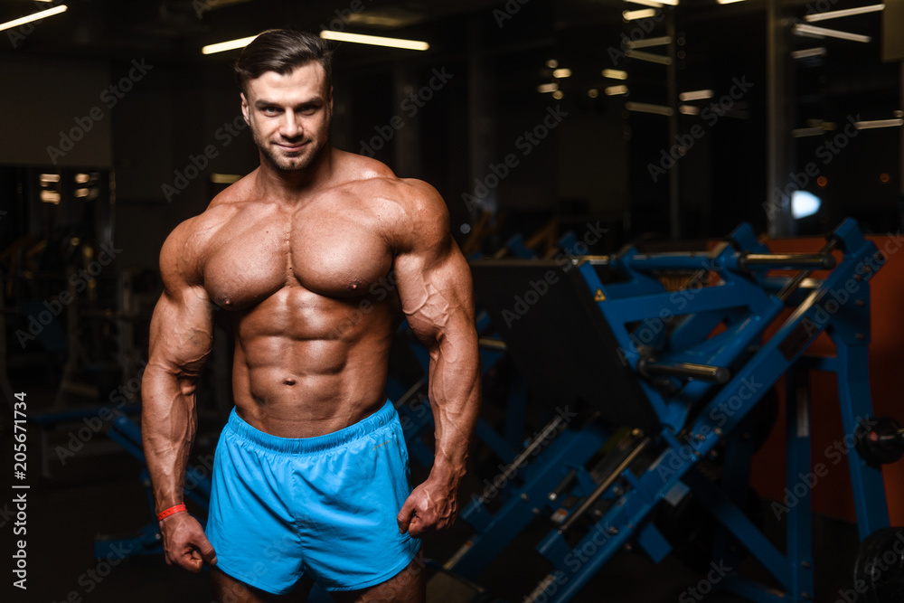 Handsome model muscle man abs workout in gym Handsome model muscle man abs workout in gym
