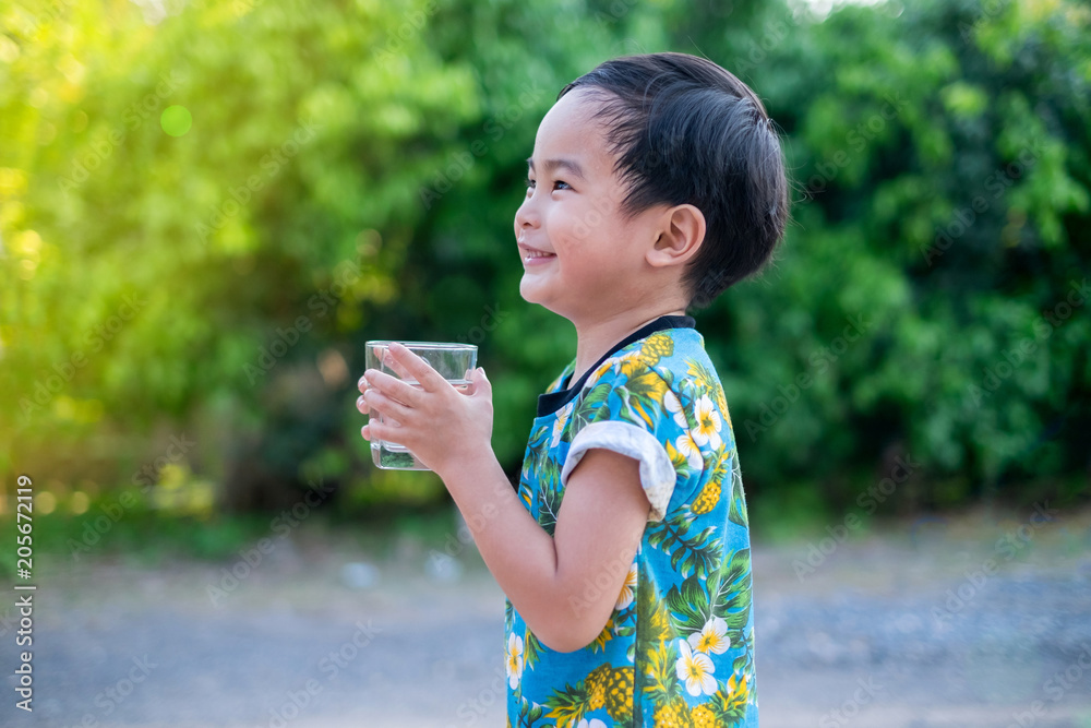 Asian Cute Boy drinking water for Healthy and Refreshing with green tree background. Asian Cute Boy drinking water for Healthy and Refreshing with green tree background.