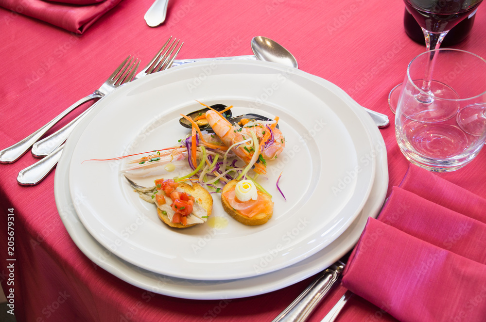 Fish snacks, Mediterranean cuisine on red tablecloth in Italian restaurant. Fish snacks, Mediterranean cuisine on red tablecloth in Italian restaurant.
