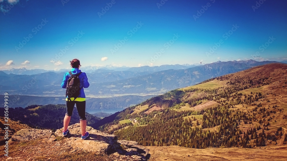 Fototapeta premium woman standing on the top of a mountain with wonderful view
