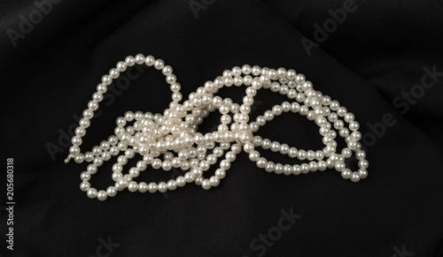 Fake pearls on a black fabric background.