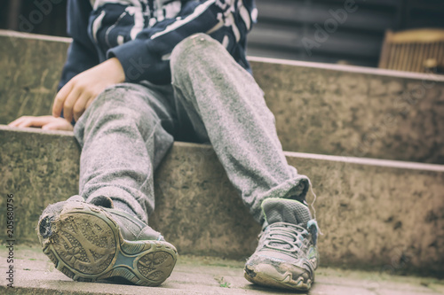 Löchrige Schuhe als Symbol für eine Kindheit in sozialer Benachteiligung photo