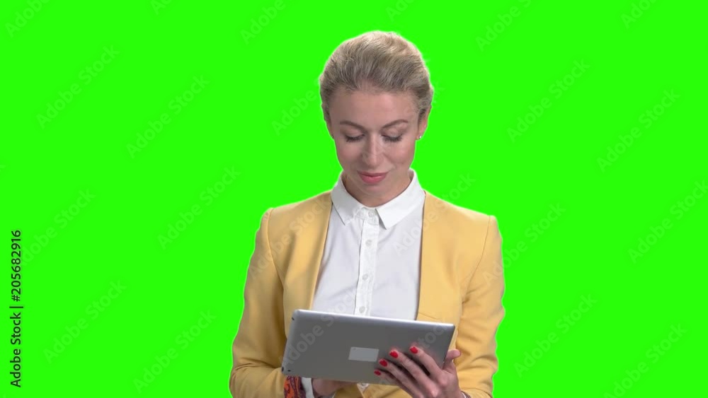 Smiling business lady using digital tablet. Portrait of elegant young female using pc tablet on green screen. People, technology, lifestyle. Smiling business lady using digital tablet. Portrait of elegant young female using pc tablet on green screen. People, technology, lifestyle.