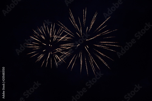 The sparks of the fireworks high in the night sky.