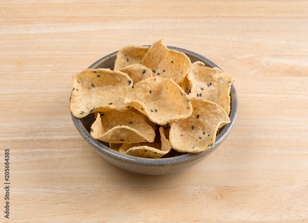 Corn tortilla dipping shells in a bowl atop a wood table. Corn tortilla dipping shells in a bowl atop a wood table.