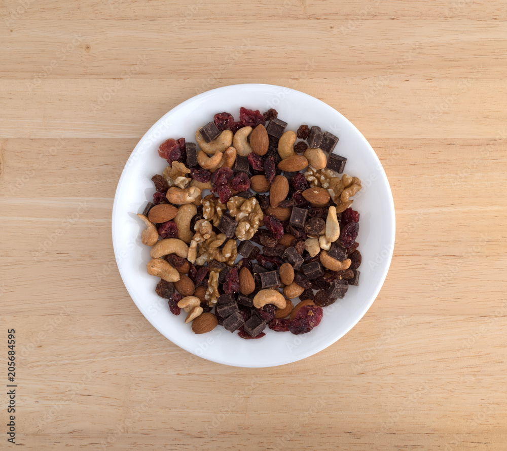 Top view of chocolate and nut mixture on a plate atop a wood table. Top view of chocolate and nut mixture on a plate atop a wood table.