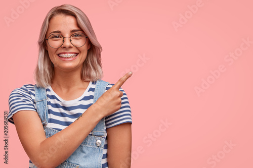Photos Portrait of beautiful stylish female with braces, has appealing look and charmin