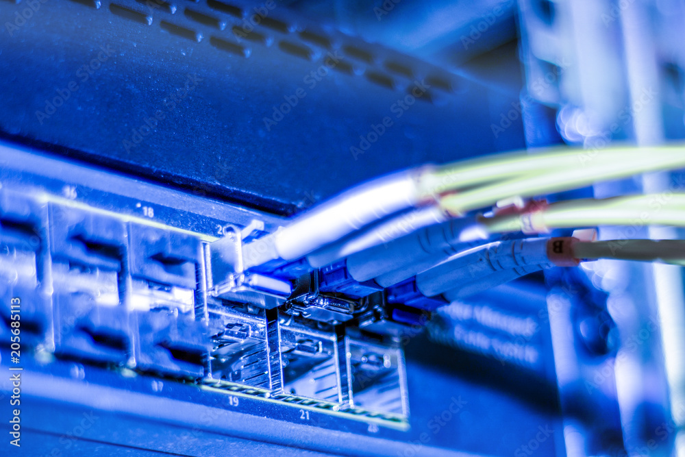 Optical Internet and network yellow wires is on the manager switches. Fiber optic cables is located on ports of server equipment. Concept of modern Internet connection. Selective focus, close up. Optical Internet and network yellow wires is on the manager switches. Fiber optic cables is located on ports of server equipment. Concept of modern Internet connection. Selective focus, close up.