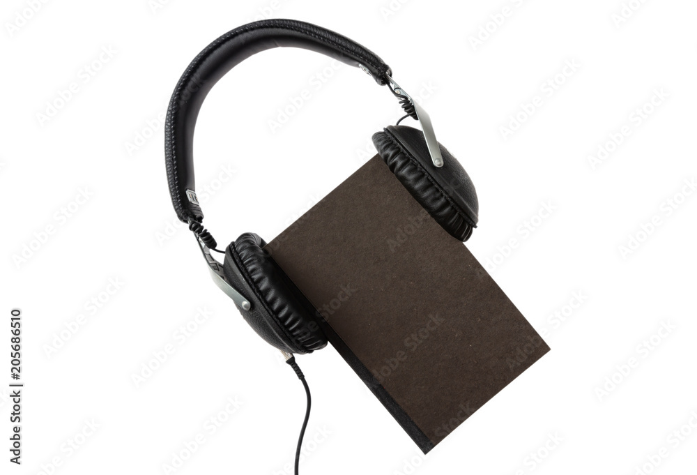 Audio book. Black book and headphones set isolated on white background, top view Audio book. Black book and headphones set isolated on white background, top view