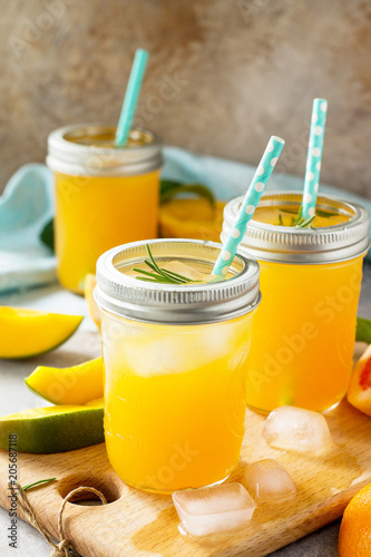Healthy juicy diet with summer vitamin drinks or a concept of vegetarian food, fresh vitamins, a homemade refreshing fruit drink made of citrus and mango.