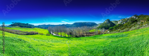 Beautiful panoramic pastoral  surrounded by evergreen trees on steep hills. Farm fields of red soil in the valley of the Alcabrichel river. A typical agricultural landscape near Vimeiro in Portugal.