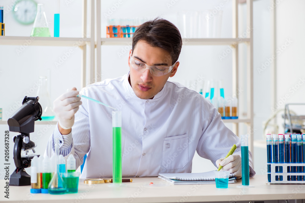 Young chemist student working in lab on chemicals Young chemist student working in lab on chemicals