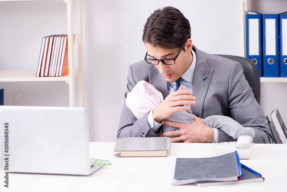 Businessman looking after newborn baby in office Businessman looking after newborn baby in office