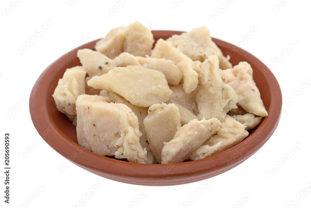 Chicken breast chunks in a small bowl isolated on a white background.