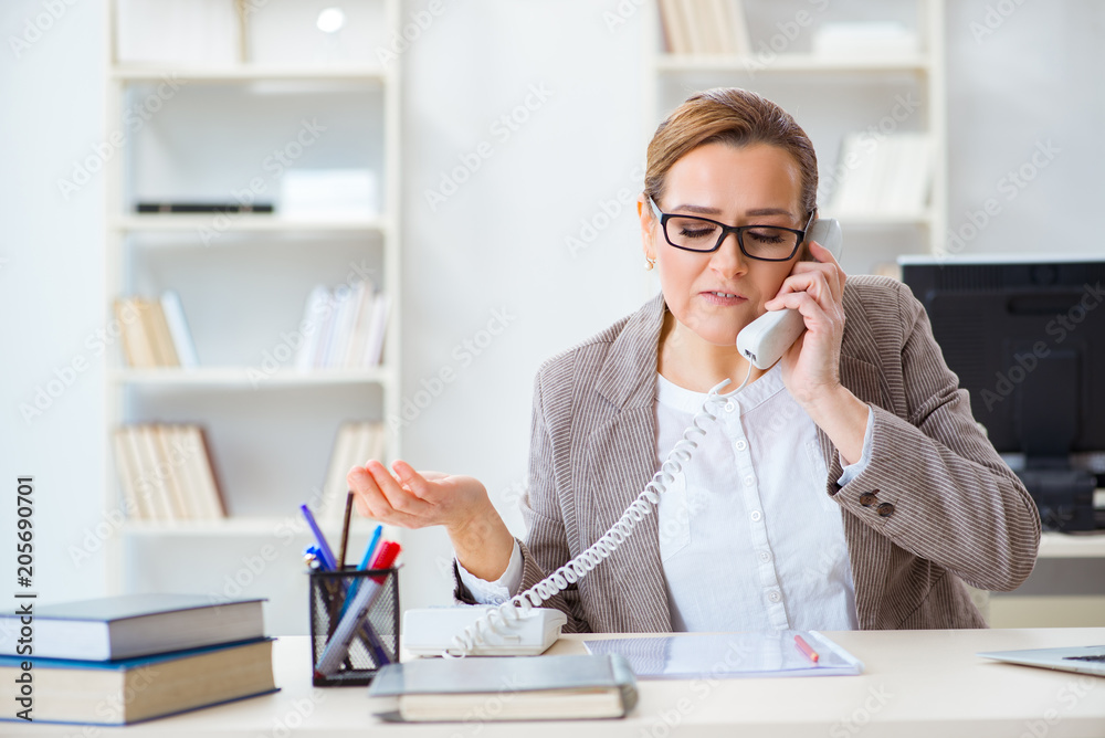 Businesswoman employee talking on the office phone Businesswoman employee talking on the office phone