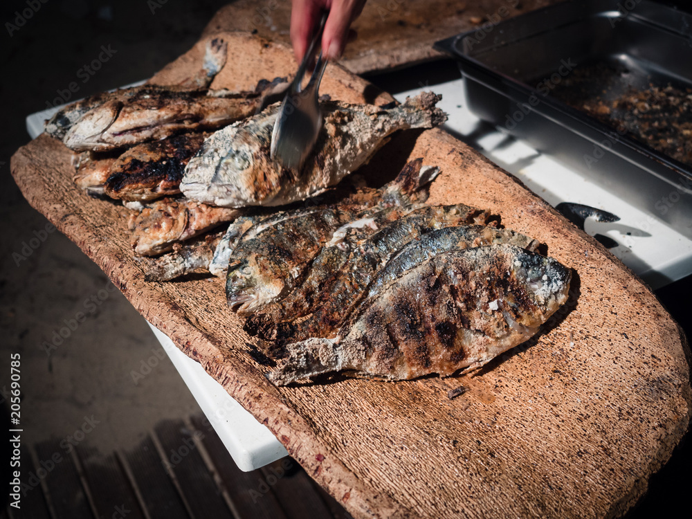 Fototapeta premium Bream cooked on the grill and served on a typical cork tray.