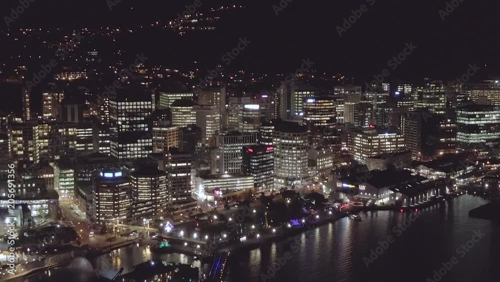 Aerial, rising shot of skyline at night, city lights and traffic in the distance. Aerial, rising shot of skyline at night, city lights and traffic in the distance.