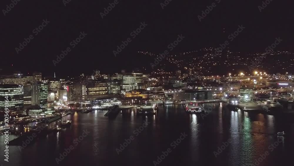 Aerial pan, city skyline and reflections on water at night. Aerial pan, city skyline and reflections on water at night.
