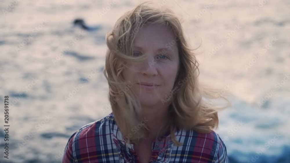 close-up portrait of mature blonde woman who loves adventure travel on the background of the sea waves and wind Strongest close-up portrait of mature blonde woman who loves adventure travel on the background of the sea waves and wind Strongest