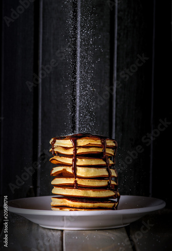 Wallpaper Mural Fresh and delicious sweet pancakes with falling sugar on top, and chocolate syrup sauce Torontodigital.ca