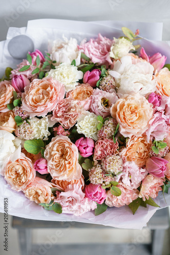 beautiful luxury bouquet of mixed flowers in woman hand. the work of the florist at a flower shop. Vertical photo