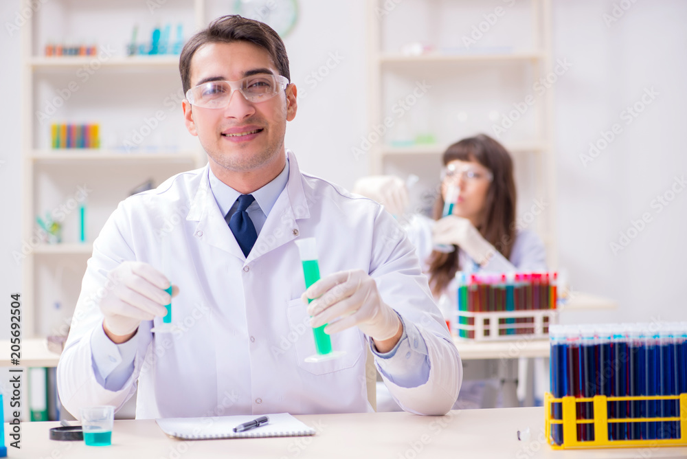 Two chemists working in lab experimenting Two chemists working in lab experimenting
