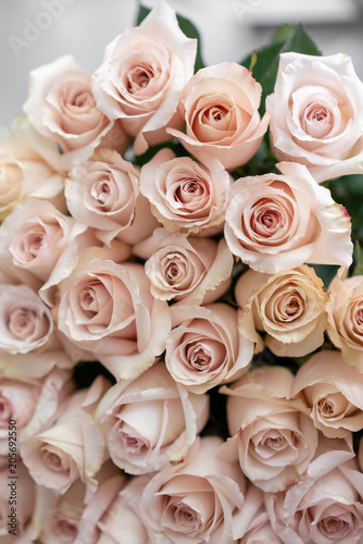 pastel pink roses. Bouquet of beautiful flowers on wooden table. Floristry concept. the work of the florist at a flower shop. Vertical photo © malkovkosta