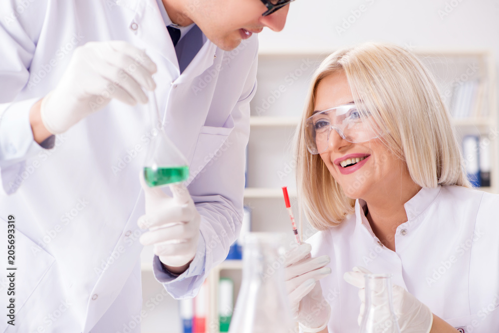 Two chemists having discussion in lab Two chemists having discussion in lab