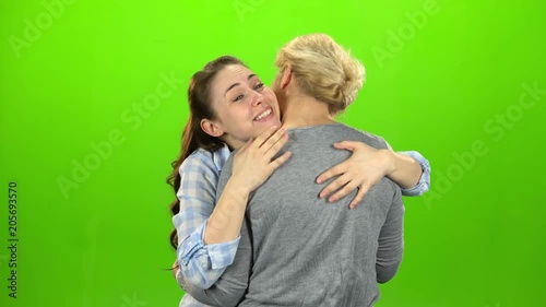 Native hugs, they are stand and talking. The daughter hugs her mother. Green screen