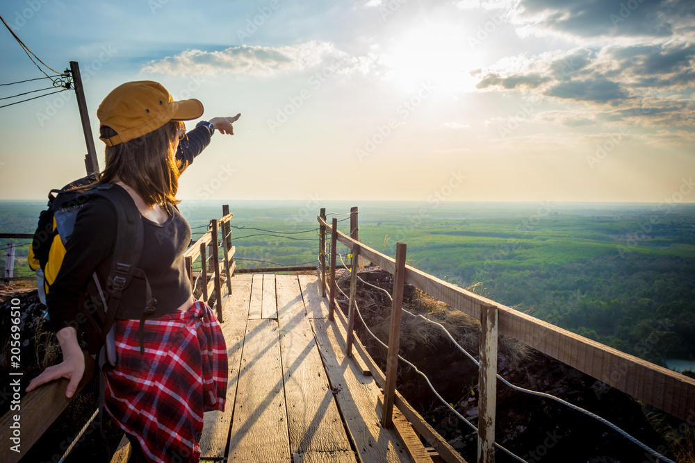 Obraz premium Tourist young woman wearing hat enjoying stand in wood bridge on the mountains.