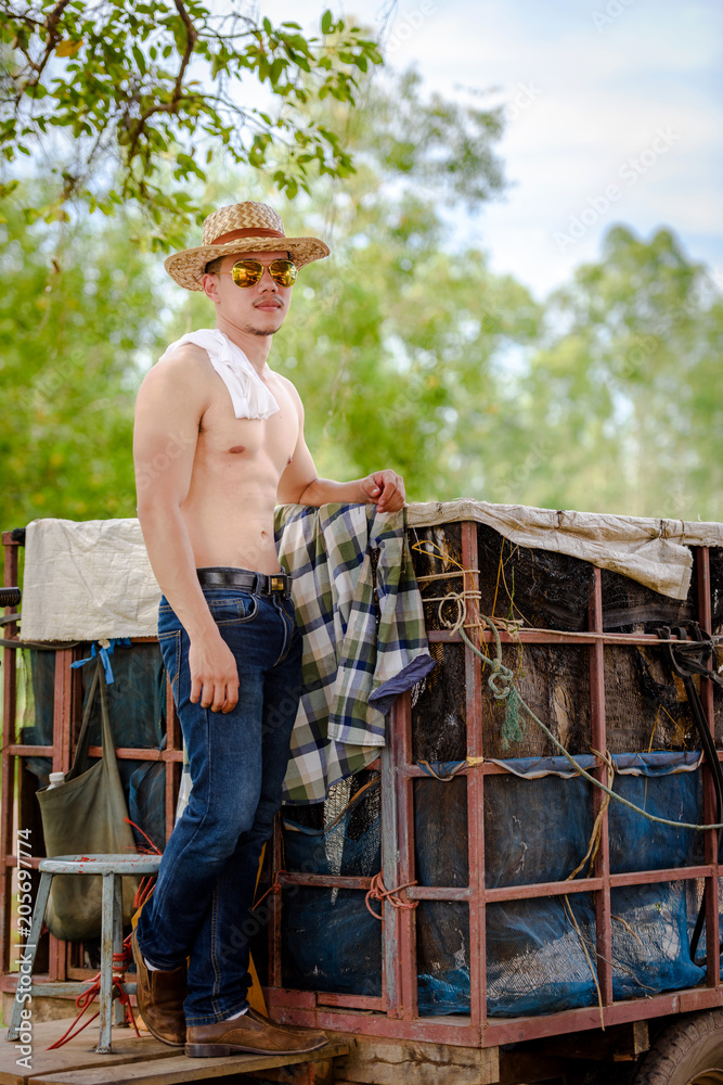 Asian farmer body bouncing. Not wearing jeans, but wearing jeans, standing  in a plow. Stock Photo | Adobe Stock