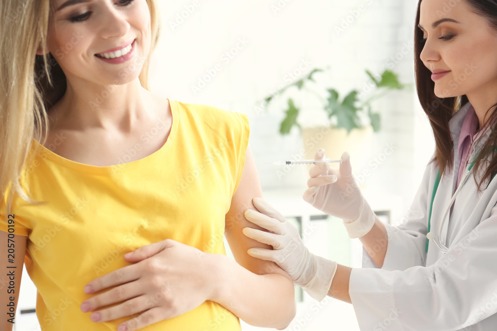 Doctor vaccinating pregnant woman in clinic Doctor vaccinating pregnant woman in clinic