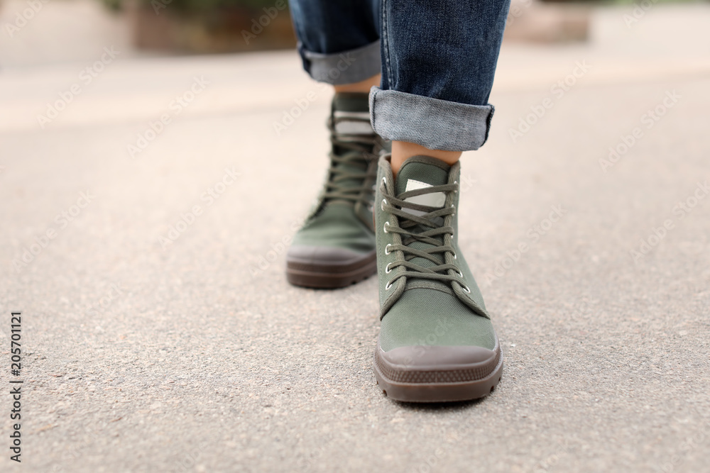 Young woman in comfortable casual shoes walking on street Young woman in comfortable casual shoes walking on street