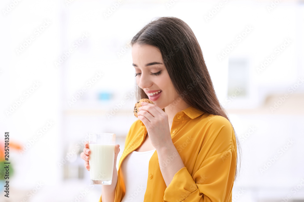 Beautiful pregnant woman drinking milk and eating cookies at home Beautiful pregnant woman drinking milk and eating cookies at home