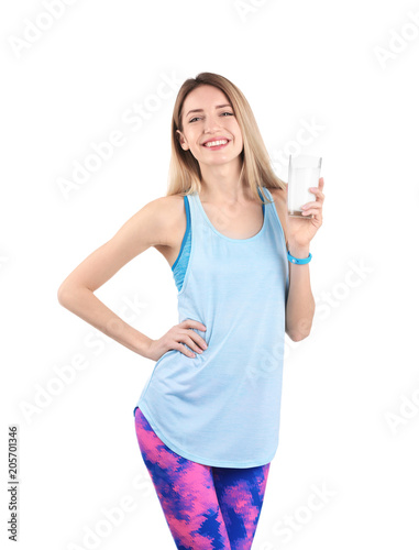 Beautiful young woman in sportswear drinking milk on white background © New Africa