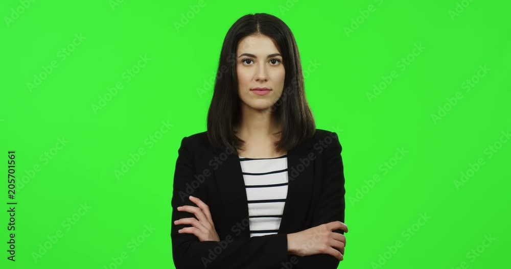 Portrait shot of the beautiful brunette young businesswoman in the black suit standing on the chroma key background and posing to the camera. Green screen. Close up Portrait shot of the beautiful brunette young businesswoman in the black suit standing on the chroma key background and posing to the camera. Green screen. Close up