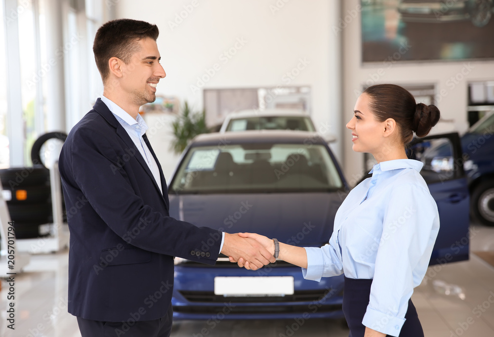 Young salesman working with client in car dealership Young salesman working with client in car dealership