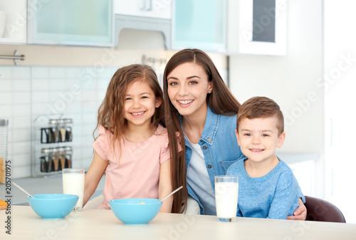 Happy family having breakfast with milk in kitchen
