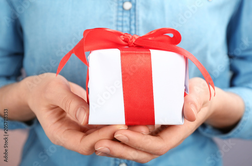 Young woman holding beautifully decorated gift box, closeup