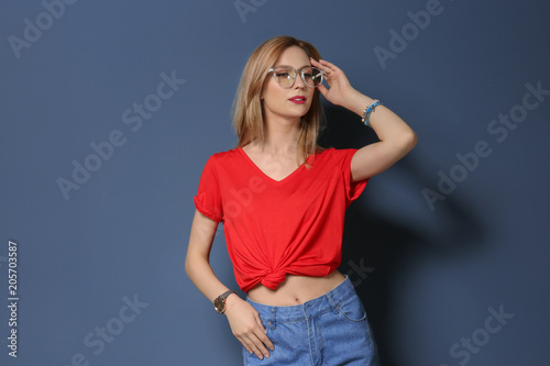 Attractive young woman in stylish outfit on color background © New Africa