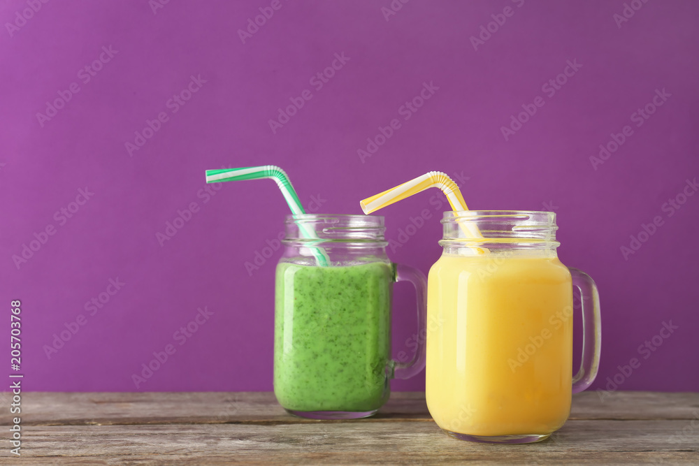 Mason jars with delicious detox smoothies on table Mason jars with delicious detox smoothies on table