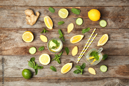 Flat lay composition with detox lemonade and ingredients on wooden background