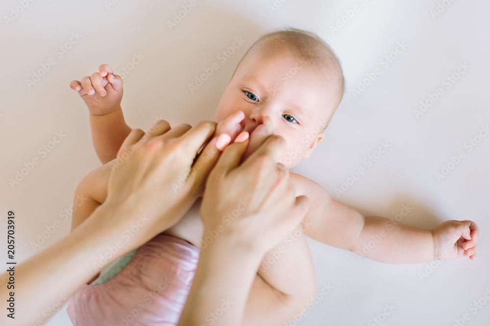 Baby massage. Mother massaging and doing gymnastic with legs of her kid Baby massage. Mother massaging and doing gymnastic with legs of her kid