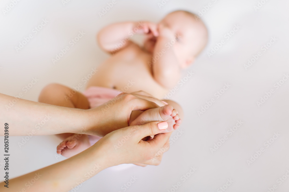 Mother hand massaging foot of her baby on white background Mother hand massaging foot of her baby on white background