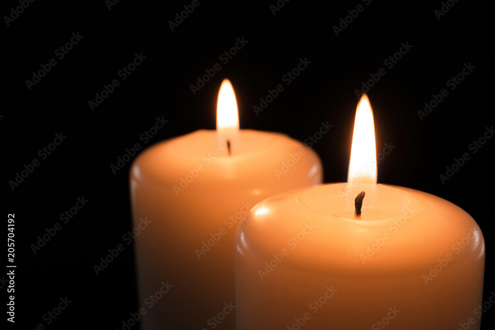 Wax candles burning on black background, closeup Wax candles burning on black background, closeup