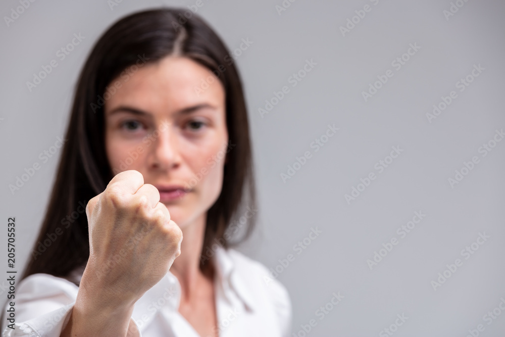Portrait of young woman threatening with fist Portrait of young woman threatening with fist