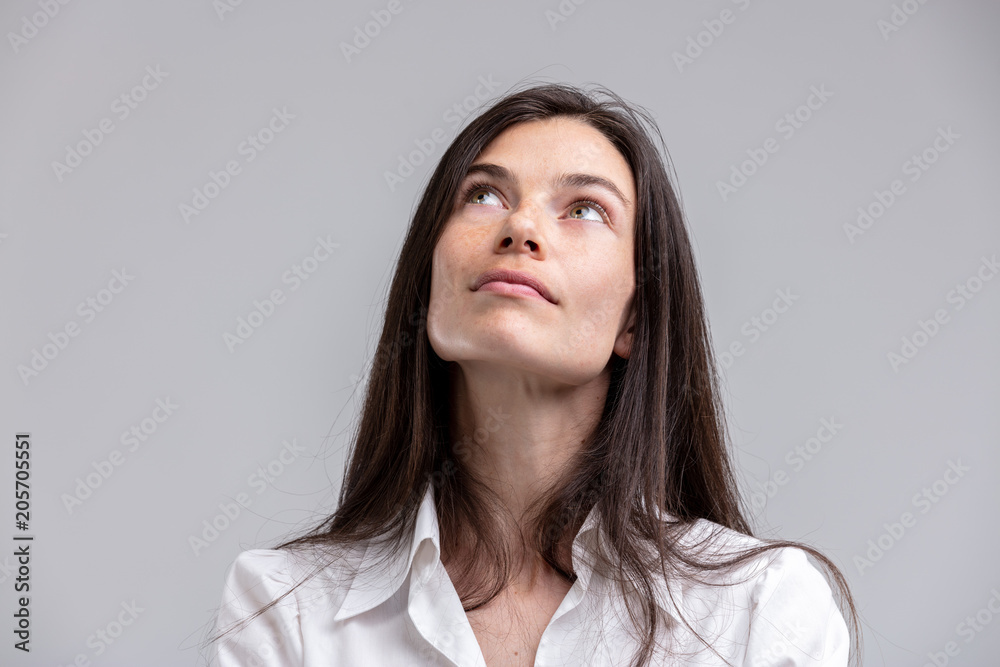 Obraz premium Thoughtful attractive woman looking up
